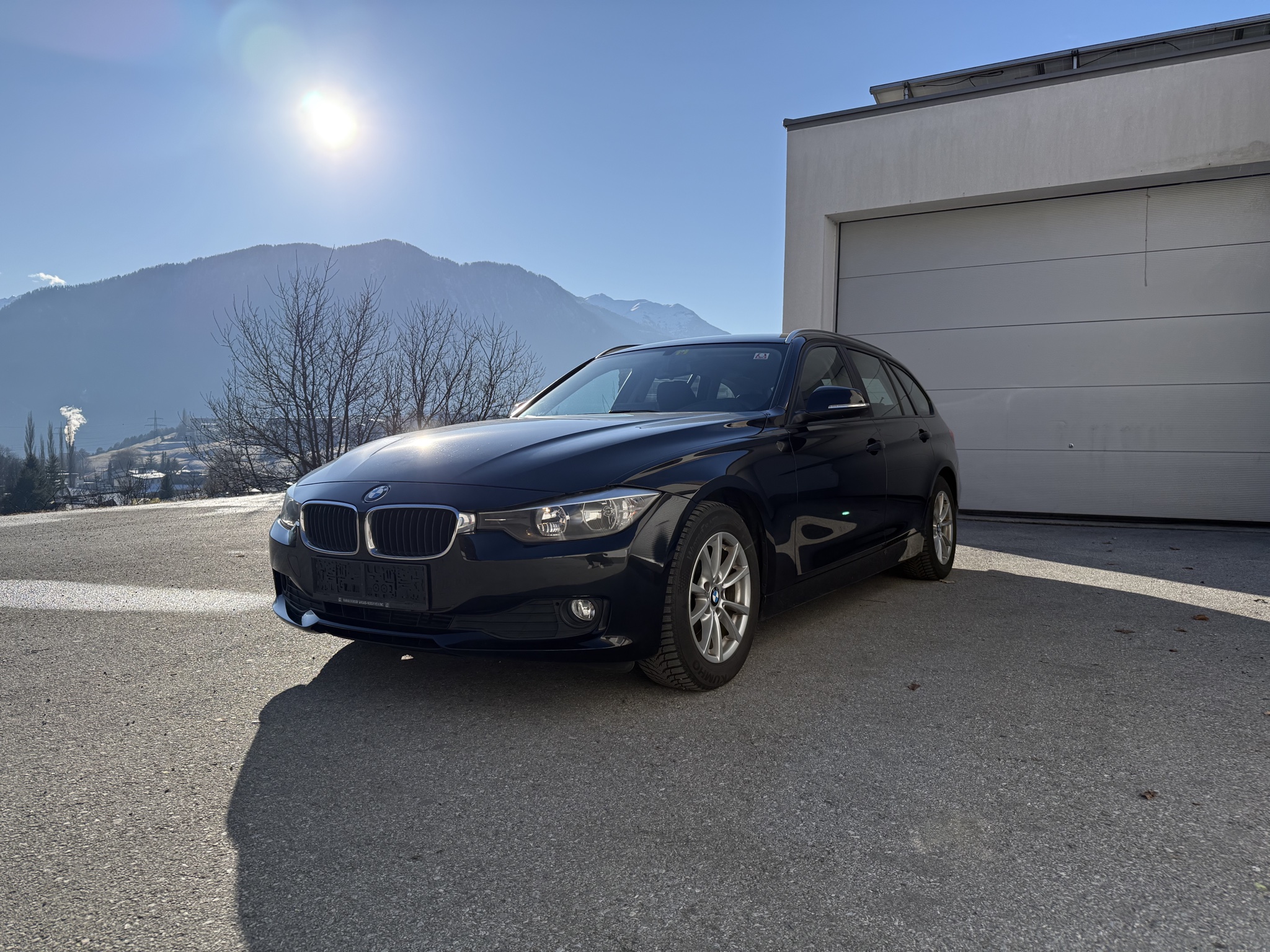 Dunkelblauer BMW 3er Touring vor Bergkulisse