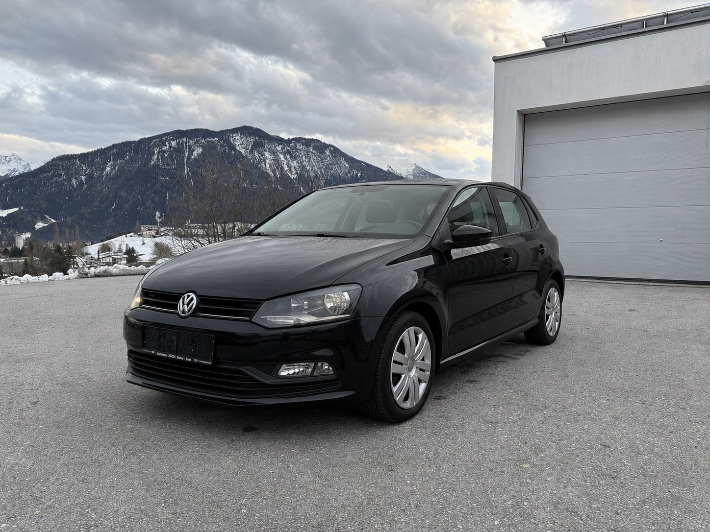 Schwarzer VW Polo vor Tiroler Bergkulisse